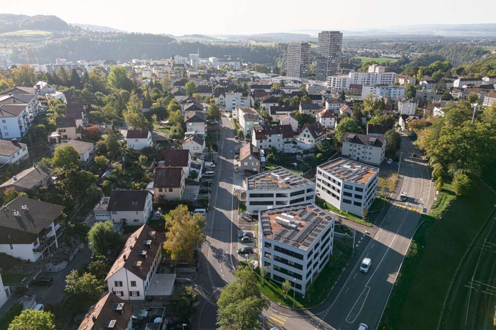 Von oben: Auf den Dächern liegen Extensivbegrünung und Photovoltaik, die Baukörper fügen sich in den Massstab der Einfamilienhaus-Nachbarschaft.