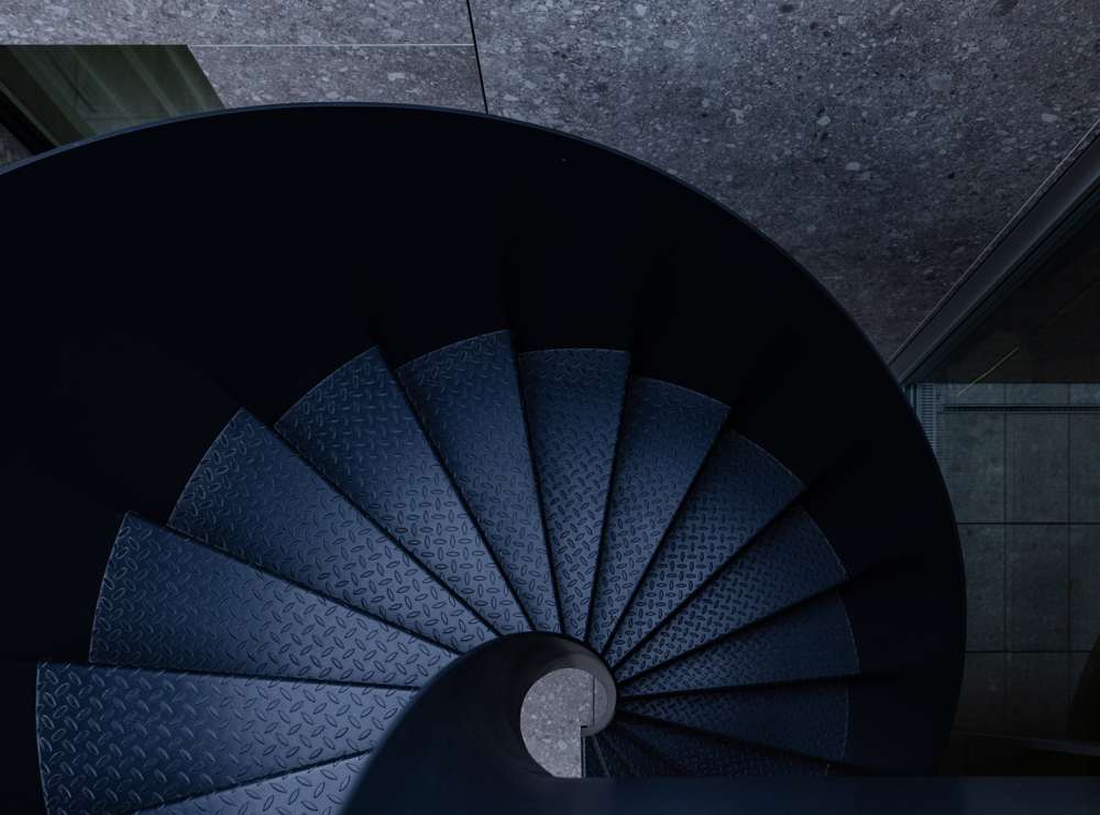 Die Wendeltreppe aus Metall von oben: ohne Mittelstütze, fugenlos wie aus einem Guss, mit Riffelblech-Stufen – sie verbindet den Patio mit dem Dachgarten.